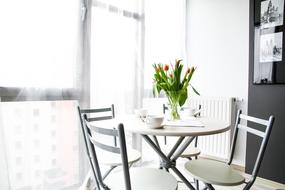 Interior of the apartment room with furniture and decorations, near the windows with light