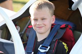 Portrait of the smiling, blonde boy, doing gliding