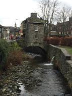 Beautiful landscape of the old Ambleside, England, with the water among the plants and buildings