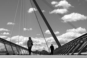 people on the bridge in black and white background