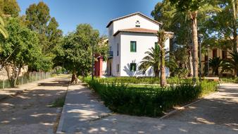 Beautiful landscape with the villa among the park in sunlight, under the blue sky
