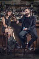 photo of a man and a woman sitting in a bar