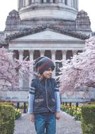 Young, cute boy, among the colorful and beautiful, blossoming plants, near the Capitol