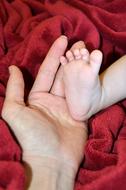 child's foot in hand as symbolism