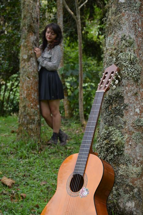 Guitar and pretty Girl leaning on tree trunks