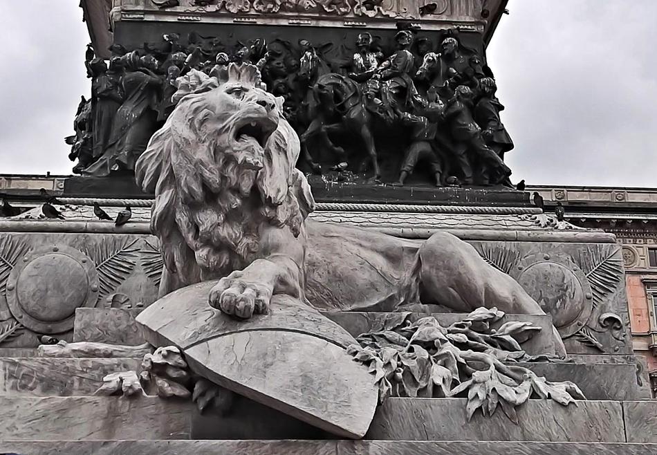 Lion with shield sculpture beneath monument