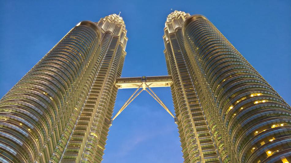 Low angle shot of the building towers with lights, in Malaysia, under the blue sky
