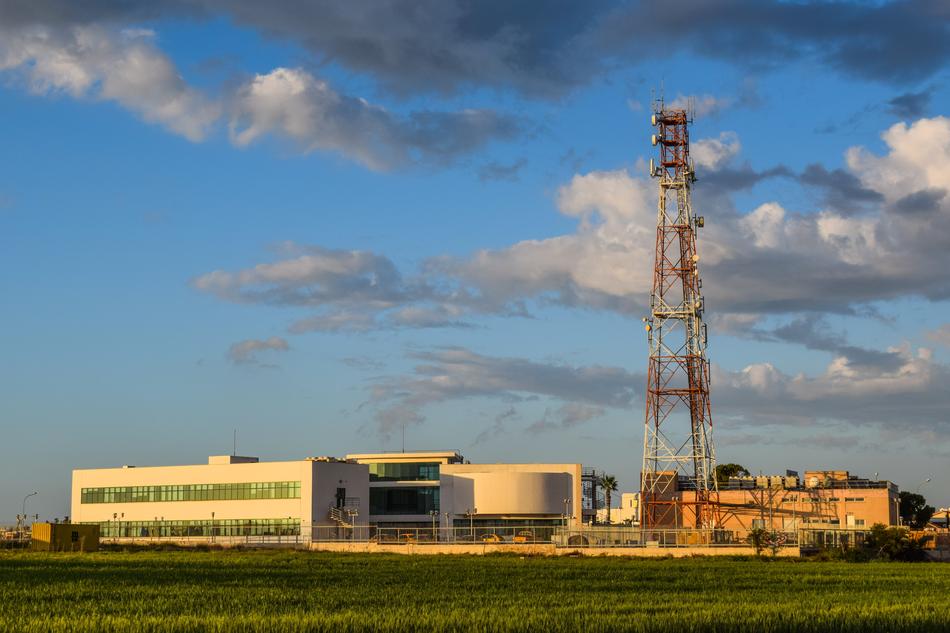 Landscape with the buildings among the green grass, in Paralimni, Cyprus, under the blue sky with clouds