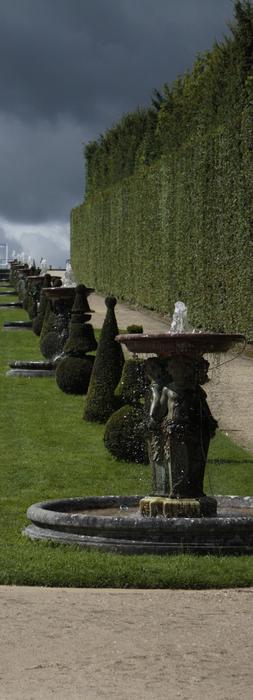 Beautiful landscape of the park with fountain in Versailles Palace, under the sky with clouds
