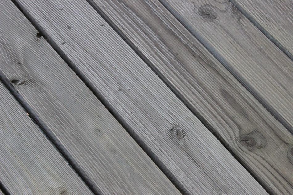 Texture of the gray wooden planks with holes