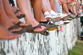 photo of shoes on the feet of children sitting on a concrete slab