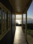 Balcony of the house in sunlight, on the coast, at background with mountains