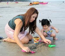 mom and child play on the beach in Thailand