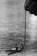 The Man Holds The Keys In His Hands on a black and white blurred background