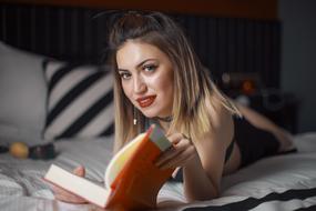 beautiful girl with a book on the bed