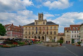 Beautiful square with colorful town hall and buildings in Weimar, Thuringia, Germany, under the blue sky with clouds