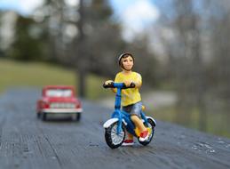 toy car and cyclist on the bench, close-up