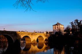 Beautiful landscape with the Old Lahn Bridge, building and plants near the water in Limburg An Der Lahn, Germany, under the blue sky