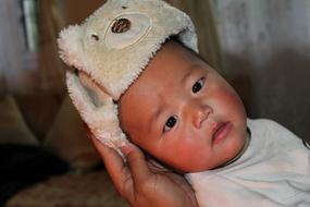 head of asian Baby girl on female hand