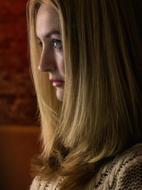 profile portrait of woman with long hair on blurred background