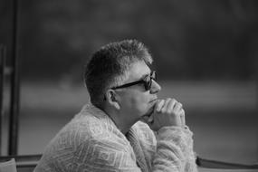 pensive man in cafe on blurred black and white background