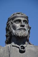 statue of a man with a beard against a clear blue sky
