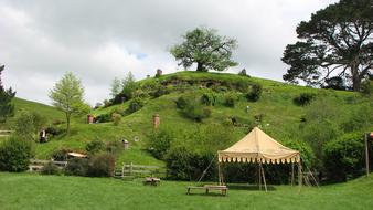 Party Tent on meadow beneath hill