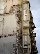 Old building with windows, under the blue sky with clouds