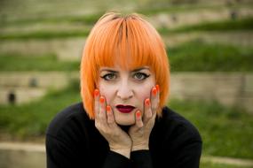 Redhead woman with hands at face outdoor