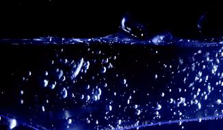 purple bubbles in liquid in the dark