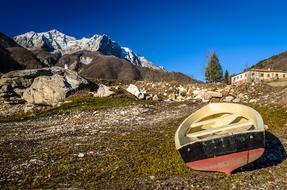 colored boat on the beach against the backdrop of the mountains