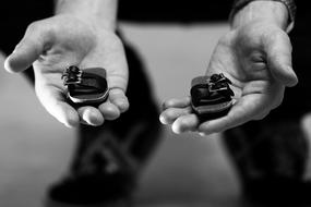 black and white photo of little shoes in the hands of a man