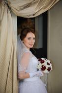 Girl on the wedding, in the beautiful, white dress, and with the colorful and beautiful flowers