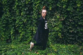 Girl in glasses, near the beautiful, colorful plants with the leaves