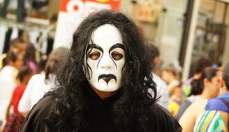 Portrait of the person with black and white mask, among the other people, on the festivities in Armenia, Quindio, Colombia