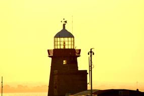 Beautiful coast of Ireland, with the lighthouse, at colorful sunset