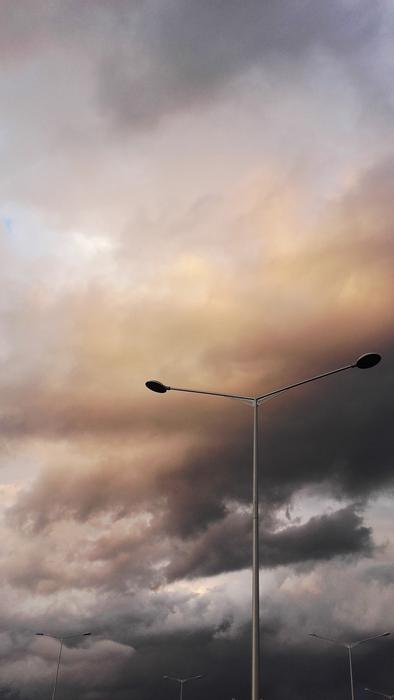 street lamp on the background of multicolored cumulus clouds