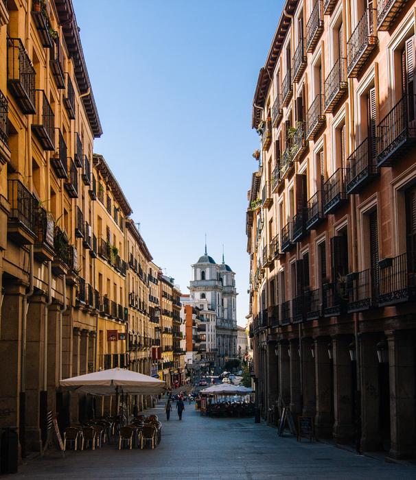 Beautiful cityscape of Calle Toledo with people, in Madrid, Spain, under the blue sky