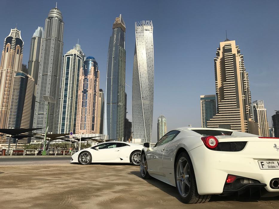 White sportscars near the buildings in Dubai Marina, under the blue sky