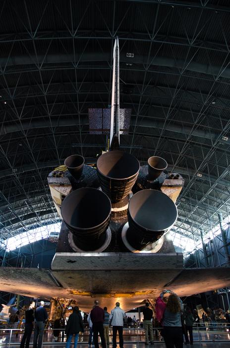 people stand near the space shuttle