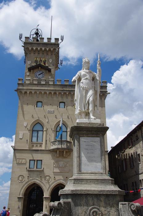 Beautiful Palazzo Pubblico architecture with the statue, in San Marino, under the blue sky with white clouds