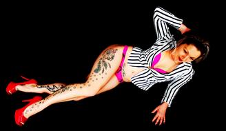 tattooed woman in pink bikini and striped jacket
