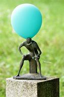 Man Sitting, contemporary Sculpture with blue balloon