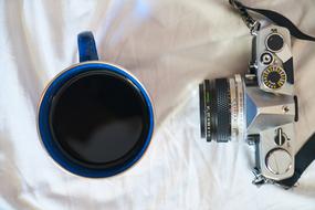 old camera near a cup of coffee