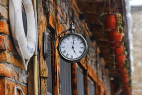 clock on the facade of a city brick building