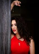 a girl in a red dress stands at the door
