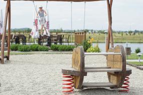 child swinging on a wooden swing in the playground