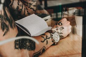 Man with tattoo on hands Reading