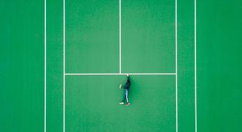 a young man lies on a tennis court