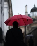 man with red umbrella on the street on blurred background